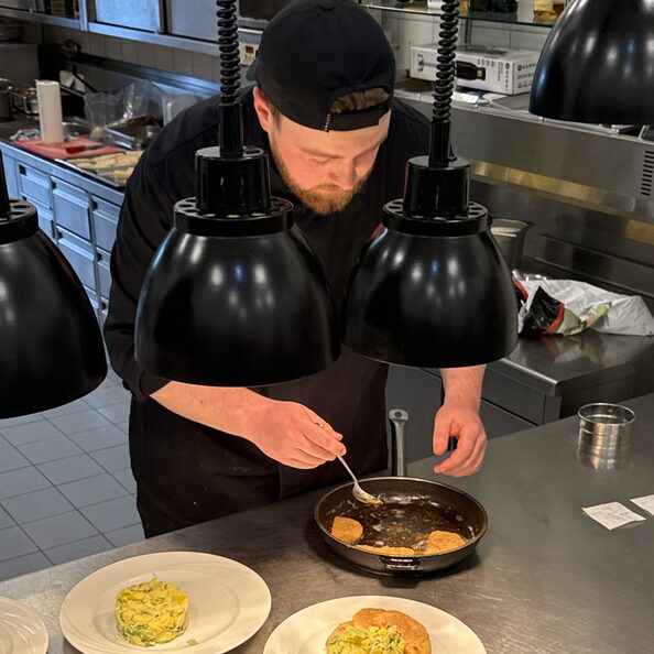Koch beim Speisen anrichten